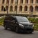 A late model minivan parked in front of a luxury hotel